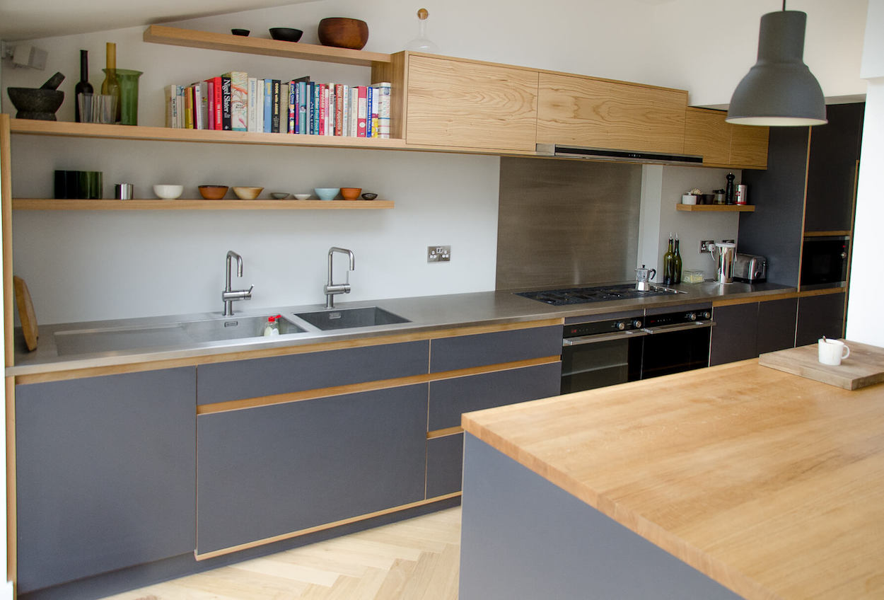 Cromwell rd bespoke handmade kitchen featuring birch plywood and oak doors finished in Fenix NTM laminate, oak detailing throughout and stainless steel worktop and oak island made in Kent.